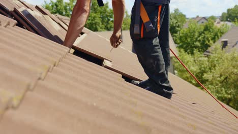 technician removing nails from rooftop tiles for installing solar panels base