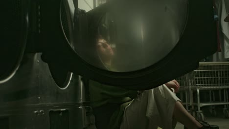 a youg latin woman having solitary reflections in the laundry room, alone sitting on the floor