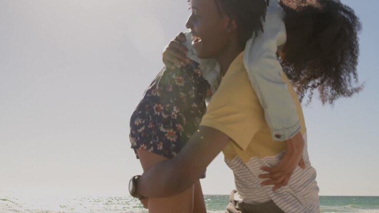 Man carrying woman on his shoulders at beach 4k
