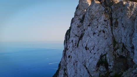 Parallax-shot-of-an-ocean-with-a-tall-hill-cliff-during-morning