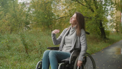 woman sits in wheelchair and looks into distance smiling