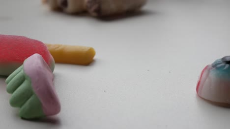 spooky themed jelies for trick or treat celebration. mixed shapes: denture, veiny, bloody eye, finger. bright colours on white surface.