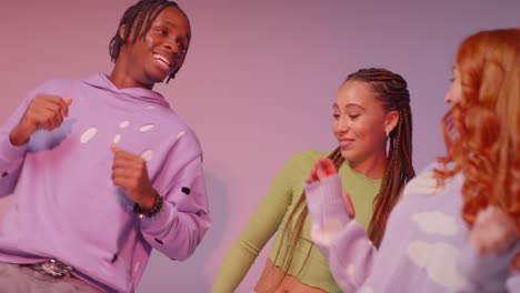 fotografía de estudio de jóvenes amigos de la generación z bailando en un club contra un fondo rosa 6