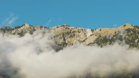 static aerial view of cloudy albanian cuka partizan hillside, blue sky day