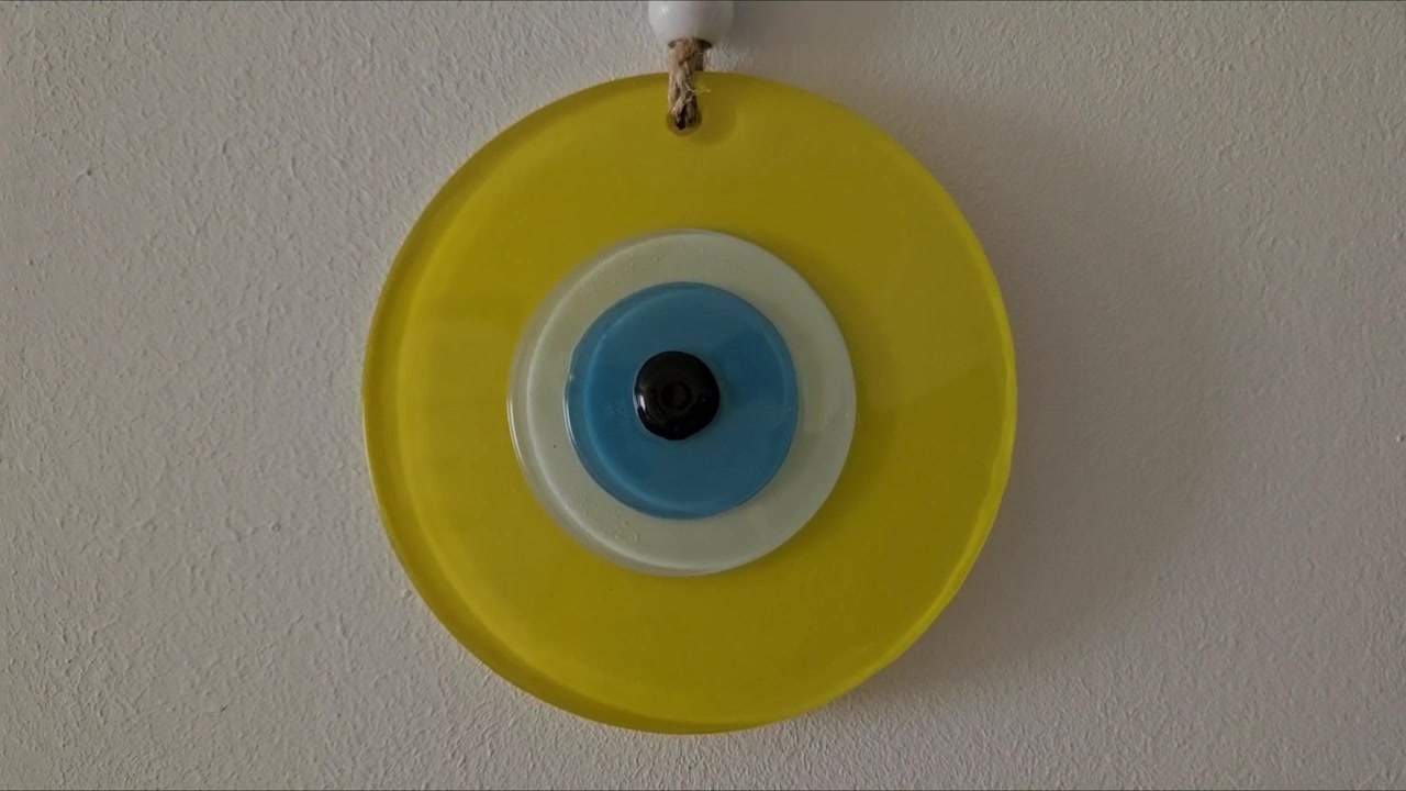 Glass evil eye wall hanging art. Traditional blue eye nazar amulet inside a yellow circle for home decor and protection aesthetic.