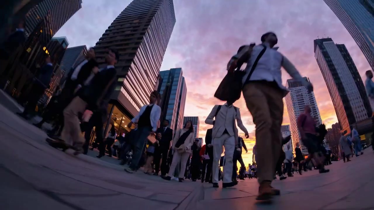 Urban Commuters Walking on City Street Against Sunset Sky