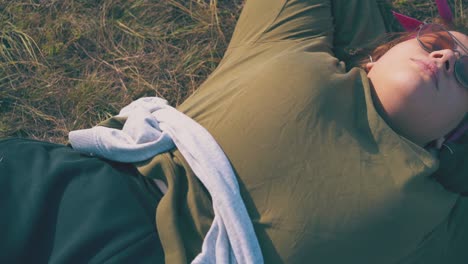 plump girl hiker lies on grass at campsite in evening