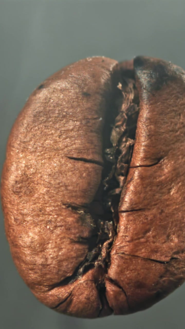 Primo piano macro di un chicco di caffè con fumo che sale