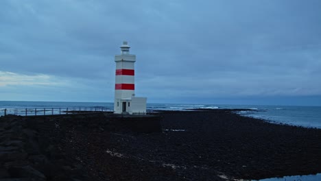 Pan-of-beautiful-old-lighthouse-on-a-small-peninsula-in-Iceland