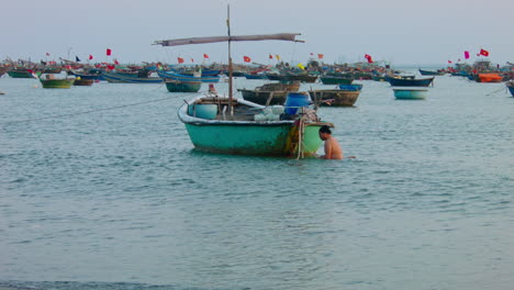 Static-shot-of-a-fisherman-in-the-ocean-trying-to-fix-his-boat-in-Da-Nang