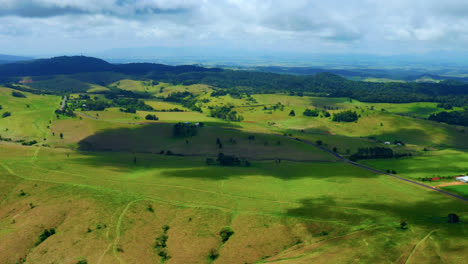 vibrant green fields in the countryside of atherton tablelands, queensland, australia - aerial drone shot