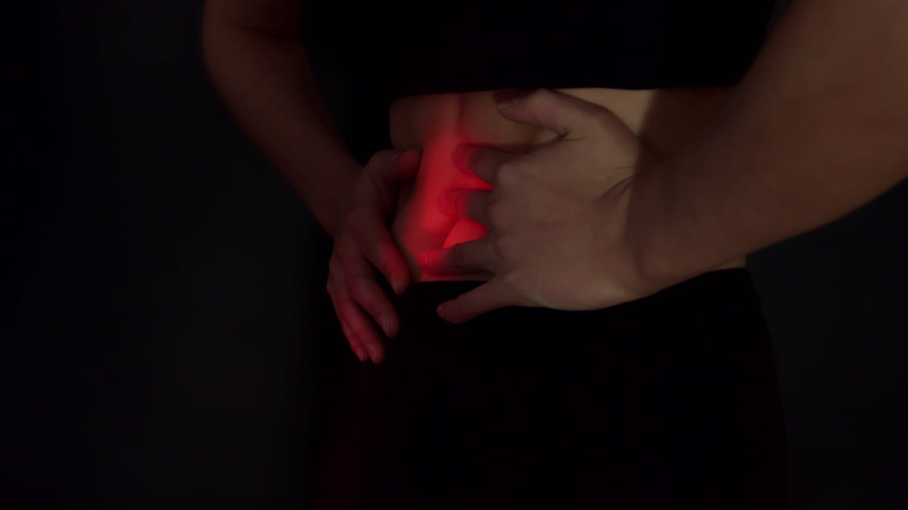 Belly cramp, stomachache. Woman with pms symptoms. Red spotlight on belly