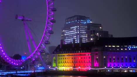 County-Hall-Y-London-Eye-Con-Iluminaciones-Coloridas-Por-La-Noche-En-La-Orilla-Del-Río-Támesis-En-Londres,-Reino-Unido