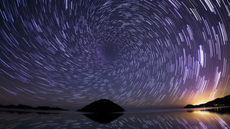 star trails over a calm sea