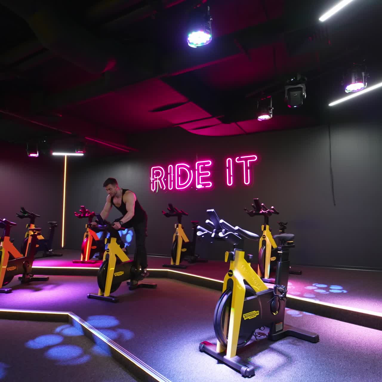 Young man working out on bike. Attractive man riding exercise bike in the gym