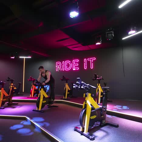 young man working out on bike. attractive man riding exercise bike in the gym