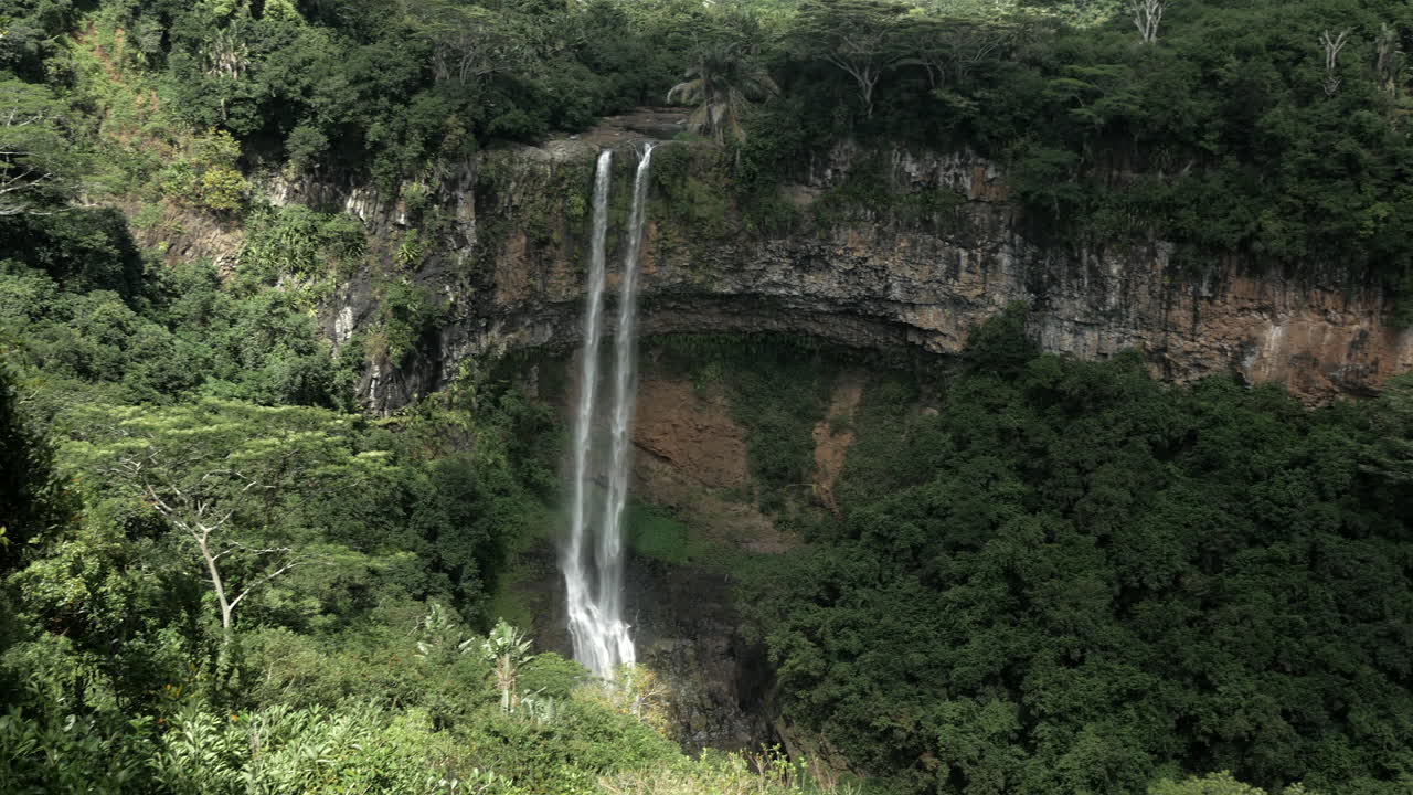 toma panorámica de una cascada profunda gigante en medio de la jungla forestal, estable