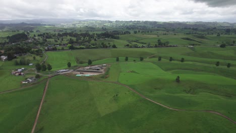 Volando-Sobre-Verdes-Tierras-De-Cultivo-Hacia-La-Carretera-En-Waikato,-Isla-Del-Norte,-Nueva-Zelanda