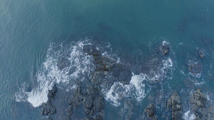 Vista aerea di onde marine che si infrangono sugli scogli