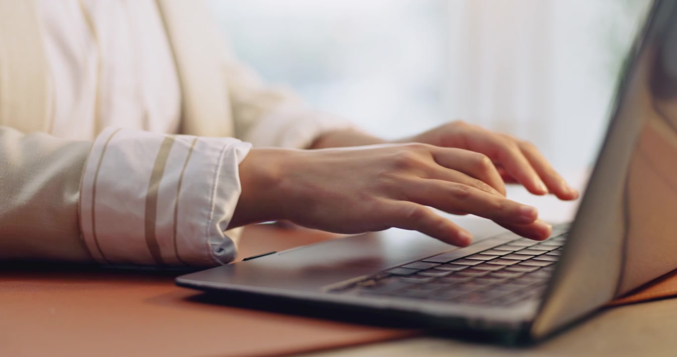 Primo piano di donna professionista che digita sul laptop in ufficio