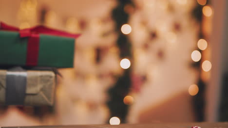 pasatiempo creativo. envoltorio de regalo. embalaje de modernas cajas de regalo de navidad en elegante papel gris con cinta roja satinada. vista superior de las manos sobre una mesa de madera blanca con ramas de abeto, decoración