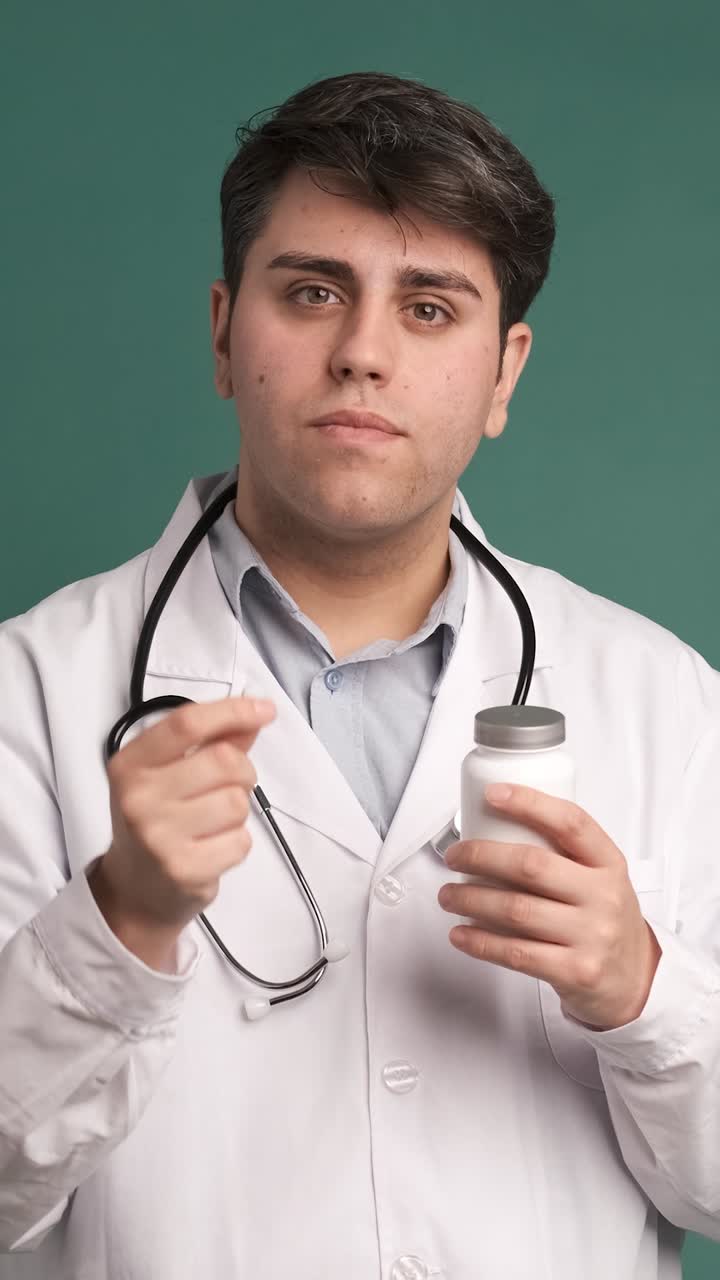 Ethnic young man doctor in white robe offering medicine on green