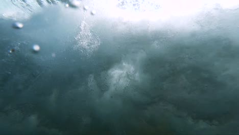 vista submarina en cámara lenta extrema de una ola rompiente en la costa tomada desde debajo de la ola