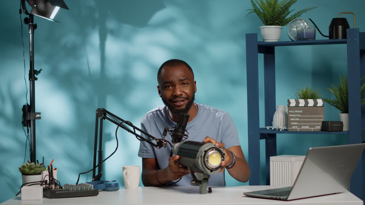 Vlogger afroamericano che realizza una recensione di un prodotto di illuminazione da studio