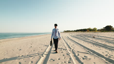 un hombre de negocios con auriculares de realidad virtual caminando por una playa.