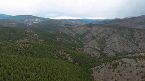 Drone-establishing-overview-of-hills-and-valleys-covered-densely-in-evergreen-trees,-Colorado