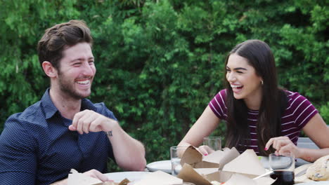 amigos multiculturales en casa sentados a la mesa disfrutando de la comida en la fiesta del jardín de verano