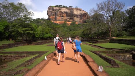 view of people walking in park below from sigiriya rock. ruins of sigiriya lion's rock palace