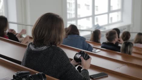 student taking photo at a lecture hall