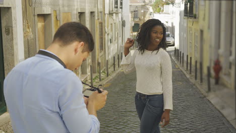 happy young couple taking photos at old city street.