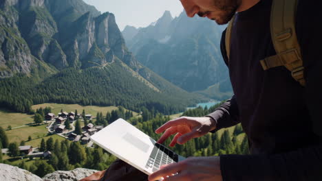 a man working on a laptop in a scenic mountain landscape
