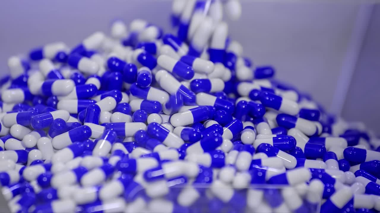 Produzione di massa automatizzata di pillole farmaceutiche per la pandemia di Covid-19. Foto fissa, primo piano