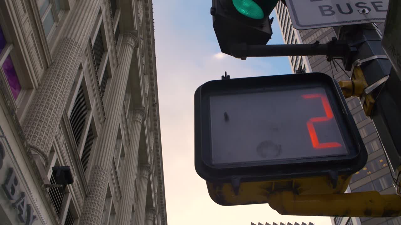 A "No Crossing" light blinking and counting down featuring an old brick building backdrop