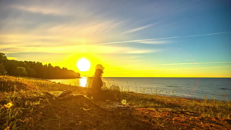 Zeitraffer-Eines-Paares,-Das-Auf-Einem-Campingplatz-Den-Farbenfrohen-Sonnenuntergang-Am-Meer-Beobachtet