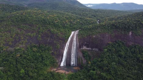 toma aérea frontal de una gran cascada ubicada en medio de la selva.
