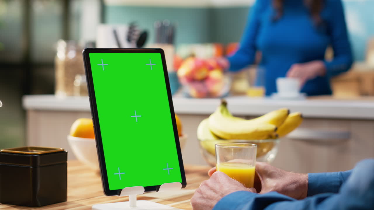 Vertical green screen with mature husband sitting at the kitchen table