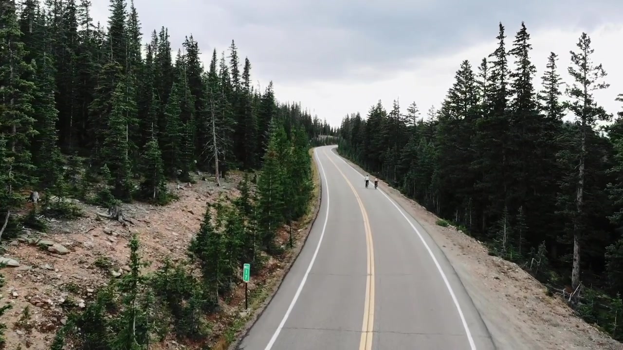 Aerial pan up reveal of two cyclists near Evergreen Colorado, USA