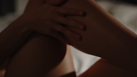 close up of hands sensuously caressing the bare leg of a pretty woman