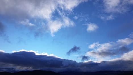 flight with a drone in the tietar valley, province of avila, one afternoon with a blue sky and low clouds hanging on the mountains that appear dark in the light of the sunset, spain