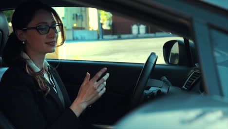 attractive caucasian business woman in a parked car while talking on the phone