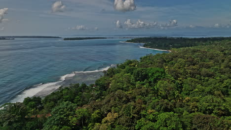 bocas del toro panama aerial v11 drone flyover paunch beach capturing natural reserve tropical rainforest and beautiful seascape with waves hitting the shore - shot with mavic 3 cine - april 2022