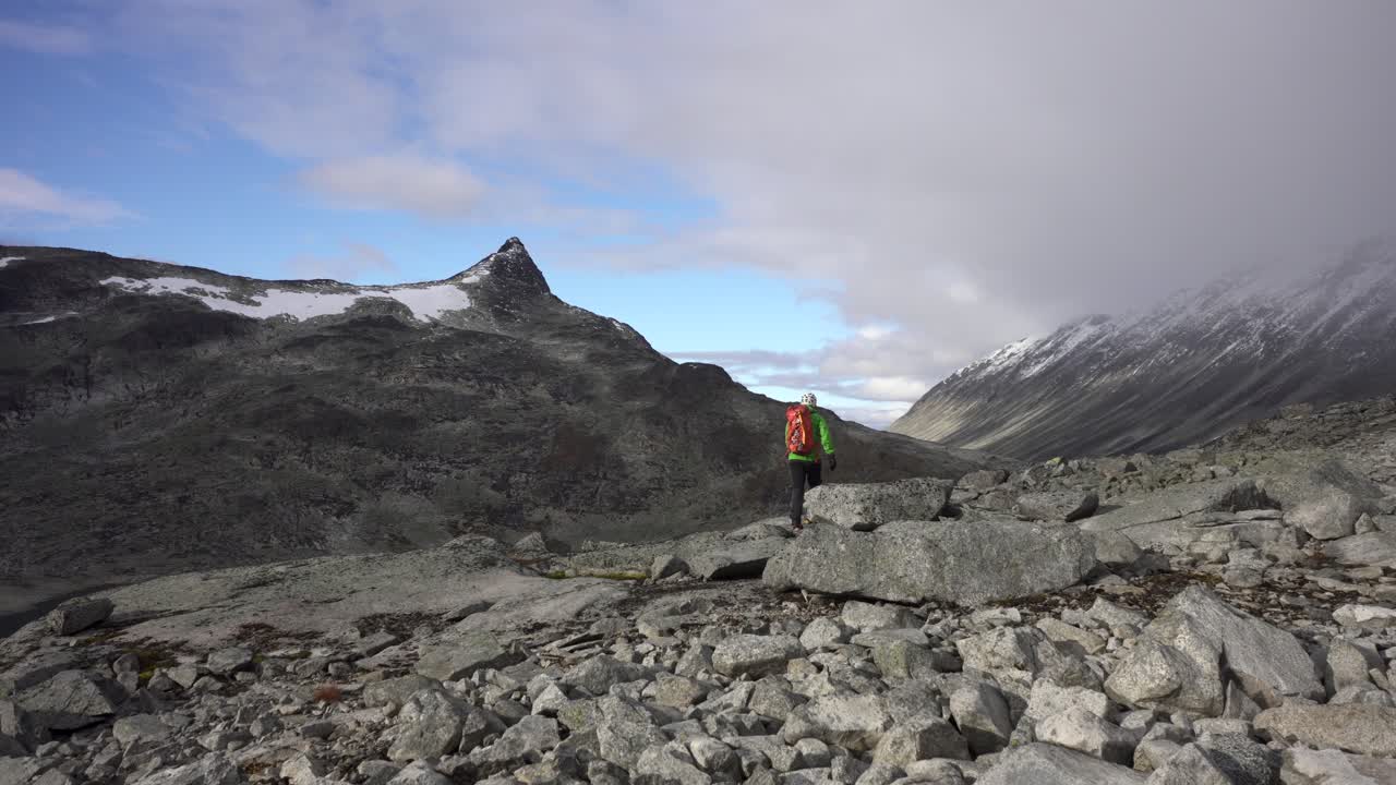늦은 오후 햇살에 노르웨이 산에서 하이킹하는 사람