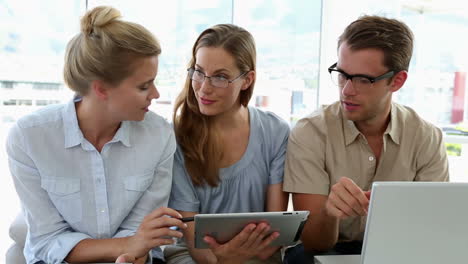 Colleagues-having-a-meeting-on-couch-with-laptop-and-tablet