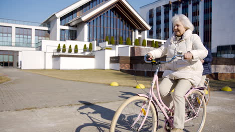 senior woman riding a bike in the street on a winter day