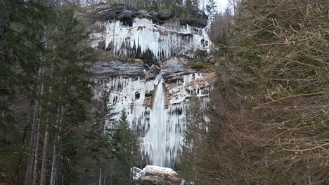 stunning frozen waterfall icicles on rocky mountain cliff on a winter day