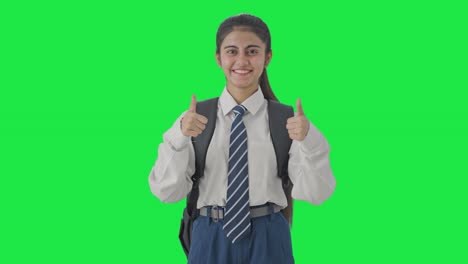 chica de la escuela india feliz mostrando los pulgares hacia arriba pantalla verde